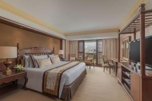 een hotelkamer met een groot bed en een televisie bij The Manila Hotel in Manilla