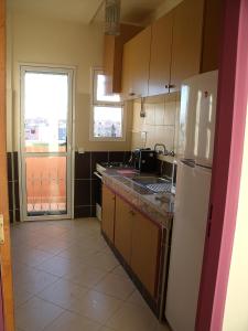 une cuisine avec un réfrigérateur blanc et une fenêtre dans l'établissement Appartement Aïda, à Marrakech