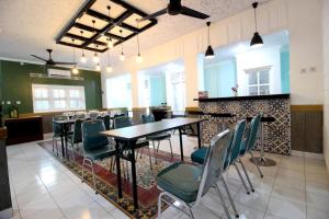 ein Restaurant mit Tischen und Stühlen in einem Zimmer in der Unterkunft RedDoorz Plus Syariah near Lempuyangan Station 3 in Yogyakarta