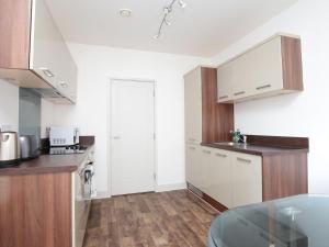 a kitchen with white cabinets and a glass table at Modern Oxford Apartment - Sleeps 4 in Oxford