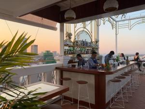 a bar on the top of a building with people sitting at it at Point Boutique Hotel in Phnom Penh