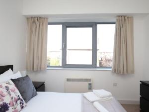 1 dormitorio con 1 cama y 2 ventanas en Modern Oxford Apartment - Sleeps 4, en Oxford