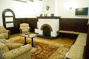 a living room with a fireplace and a table and chairs at Pensiunea Rhein in Azuga