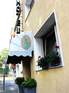 a building with a window with plants and a sign at Liberty Hotel Cologne in Cologne