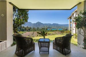 a patio with three chairs and a table with a view at BBs Biz E HBR 4104/5/6 in Princeville