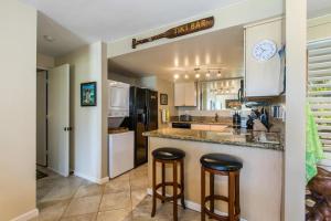 a kitchen with two bar stools at a counter at BBs Biz E HBR 4104/5/6 in Princeville