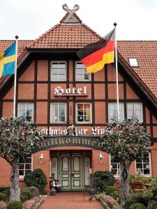 ein Gebäude mit zwei Flaggen davor in der Unterkunft Hotel Gasthaus zur Linde in Seevetal
