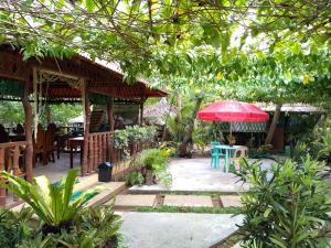 a patio with a table and an umbrella at Enna's Place in Coron