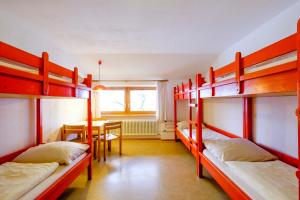 Pokój z 3 łóżkami piętrowymi i stołem w obiekcie DJH Jugendherberge Pottenstein w mieście Pottenstein