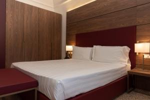 um quarto de hotel com uma cama grande com lençóis brancos em Palazzo Scamozzi em Vicenza