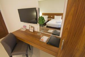 a room with a desk with a television and a bed at Mango Suites Cauayan in Cauayan City