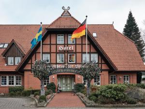 a building with two flags in front of it at Hotel Gasthaus zur Linde in Seevetal