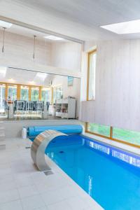 a large swimming pool in a large room with a pool at Villa Hausma in Hiiumaa