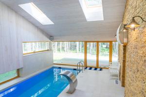 a swimming pool in a house with a ceiling with windows at Villa Hausma in Hiiumaa