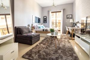 a living room with a couch a chair and a table at Frank Porter - Elite Sports Residence in Dubai