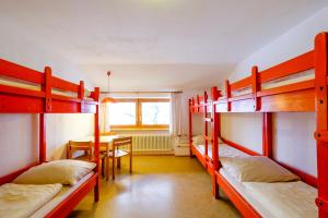 a room with four bunk beds and a table at DJH Jugendherberge Pottenstein in Pottenstein