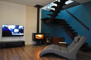 a living room with a couch and a tv and a staircase at Villa Helena in Nowe Warpno