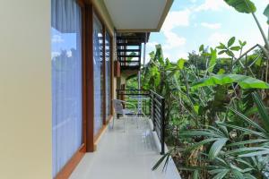 a balcony of a house with chairs and plants at Sunari Guest House in Canggu