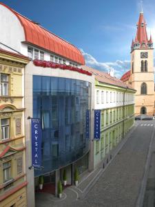 un bâtiment avec une tour d'horloge dans une rue dans l'établissement EA Hotel Crystal Palace, à Prague