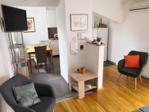 a living room with two chairs and a table at Apartman Kiss in Osijek