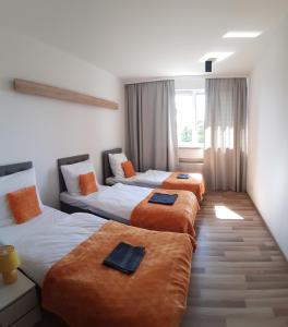 ein Hotelzimmer mit 3 Betten in Folge in der Unterkunft Hotel Miodowy in Dzierżoniów