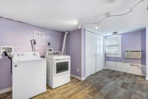 cocina con paredes de color púrpura, lavadora y secadora en Newly-renovated Comfortable Studios Near All NOLA Hot Spots, en Nueva Orleans