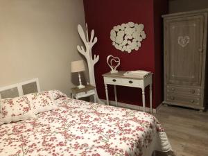 1 dormitorio con 1 cama y 1 mesa con lámpara en Lagalerne, en Neuville-du-Poitou