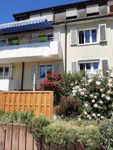 uma casa com uma cerca e flores à frente dela em BodenSEE Privatzimmer "Haus am Weinberg Konstanz" em Constança