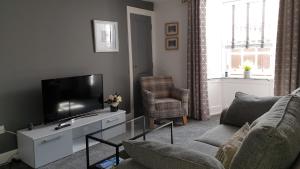 a living room with a flat screen tv and a couch at 24 east green. in Anstruther