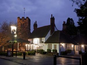 un edificio con una torre de reloj encima en The Black Horse Fulmer, en Fulmer