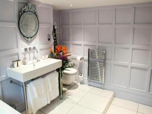 a bathroom with a sink and a toilet and a mirror at The Black Horse Fulmer in Fulmer