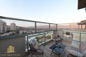 een balkon met uitzicht op de stad bij view point family suite in Eilat