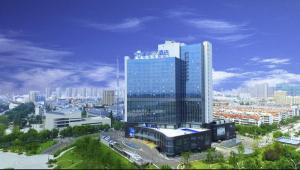 een uitzicht op een stad met een groot glazen gebouw bij Days Hotel & Suites by Wyndham Jiangsu Xinyi in Xinyi