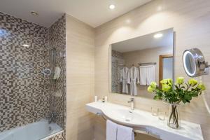 a bathroom with a sink and a shower and a tub at Royal Palm Resort & Spa - Adults Only in Playa Jandia