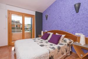 een slaapkamer met een bed en een paarse muur bij Llac Gran in Alcudia