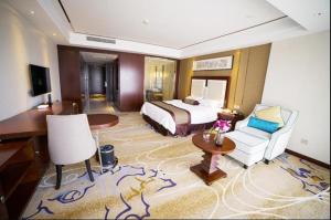 een hotelkamer met een bed en een bureau bij Days Hotel & Suites by Wyndham Jiangsu Xinyi in Xinyi