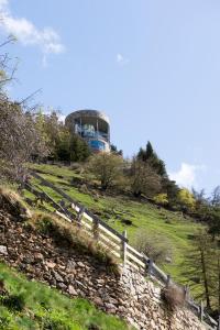 uma casa no topo de uma colina com uma cerca em Turm Chalet em Laces