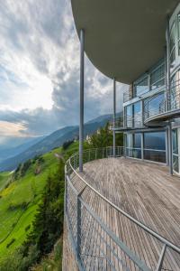 a house with a balcony with a view of the mountains at Turm Chalet in Laces