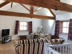 sala de estar con 2 sofás y TV en The Granary, Wolds Way Holiday Cottages, spacious 3 bed cottage, en Cottingham