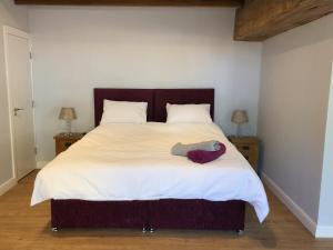 1 dormitorio con 1 cama blanca grande y 2 mesitas de noche en The Granary, Wolds Way Holiday Cottages, spacious 3 bed cottage, en Cottingham