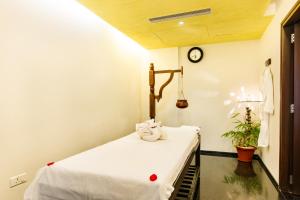 a room with a bed with a clock on the wall at Flora Airport Hotel and Convention Centre Kochi in Nedumbassery