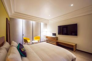 a bedroom with a bed and a desk and a television at Soho Hotel Airport in Daegu