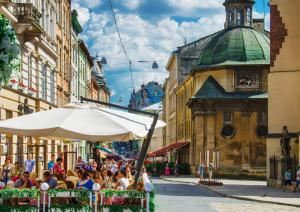 リヴィウにあるАпартаменти в центрі Львова - 1 хв до Площі Ринокの市の通りに座る人々