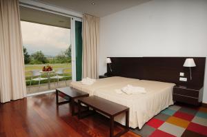 um quarto com uma cama e uma varanda com uma mesa em INATEL Vila Ruiva em Vila Ruiva