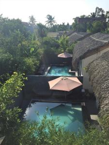 un complejo con 2 piscinas con sombrillas y árboles en Palm View Villa, en Hoi An