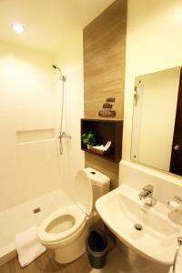 a bathroom with a toilet and a sink and a shower at Hotel Fleuris in Puerto Princesa City