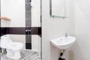 a bathroom with a toilet and a sink at SUPER OYO 617 Sukaraja Residence Syariah in Bandung