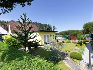 a garden with a pine tree and a house at Ferienhaus Smerzinski in Bergen auf Rügen