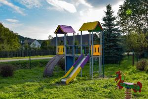 a playground with a slide in the grass at Bieszczadzka Kraina in Ustrzyki Dolne