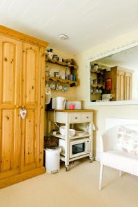 a kitchen with a cabinet and a stove in a room at Cosy Cottage ground floor bedroom ensuite with private entrance in Chichester